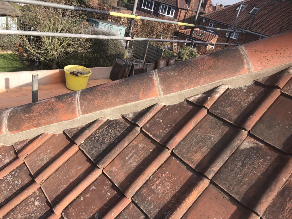 Ridge tiles being installed with dry ridge system